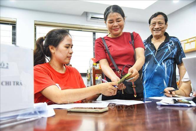 Người dân đến đăng ký nhận quà tại điểm chi trả phường Bồ Đề (Hà Nội). Ảnh: Minh Quyết - TTXVN