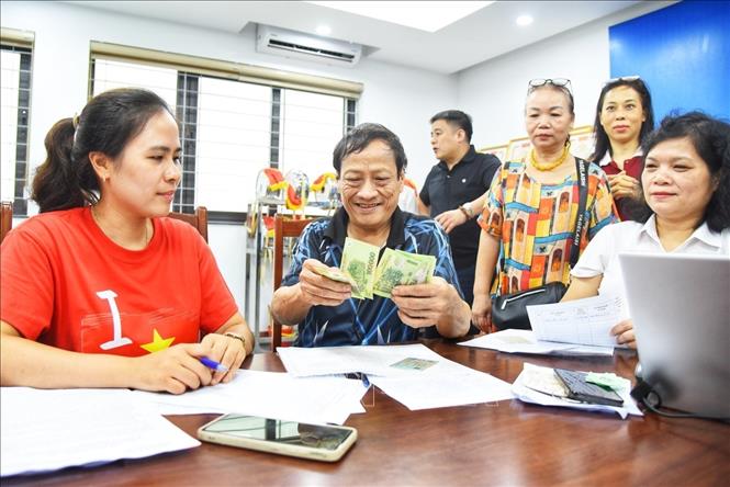 Người dân đến đăng ký nhận quà tại điểm chi trả phường Bồ Đề (Hà Nội). Ảnh: Minh Quyết - TTXVN