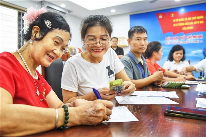 Người dân đến đăng ký nhận quà tại điểm chi trả phường Bồ Đề (Hà Nội). Ảnh: Minh Quyết - TTXVN