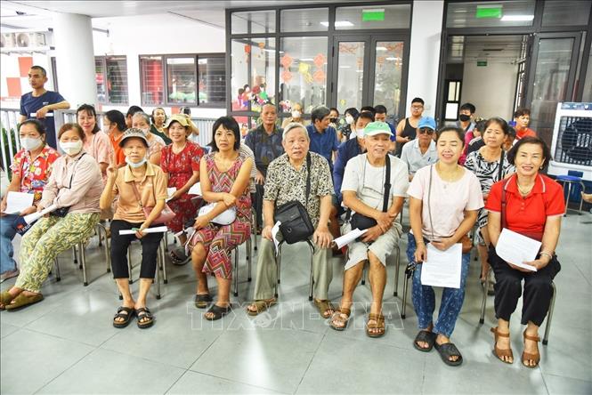 Người dân đến đăng ký nhận quà tại điểm chi trả phường Bồ Đề (Hà Nội). Ảnh: Minh Quyết - TTXVN