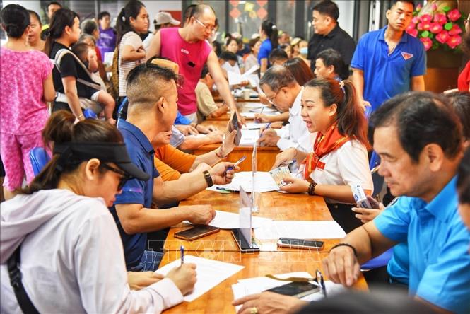 Người dân đến đăng ký nhận quà tại điểm chi trả phường Bồ Đề (Hà Nội). Ảnh: Minh Quyết - TTXVN