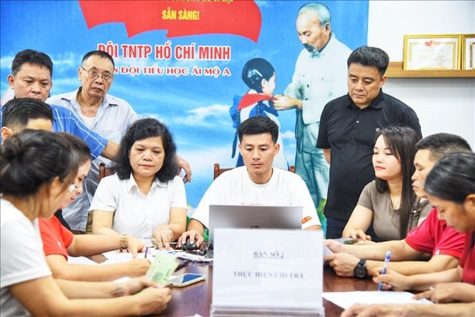 Người dân đến đăng ký nhận quà tại điểm chi trả phường Bồ Đề (Hà Nội). Ảnh: Minh Quyết - TTXVN