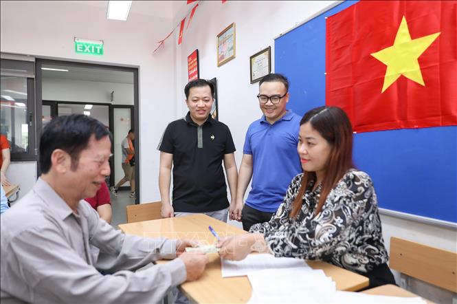 Chủ tịch phường Việt Hưng Vũ Xuân Trường và lãnh đạo phường giám sát quá trình tặng quà. Ảnh: Thành Phương – TTXVN