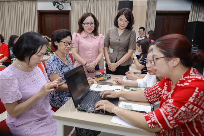 Phó Bí thư Thường trực Đảng ủy phường Cửa Nam Phạm Thị Thu Thuỷ và Phó Chủ tịch UBND phường Trịnh Ngọc Trâm giám sát quá trình tặng quà. Ảnh: Thành Phương – TTXVN