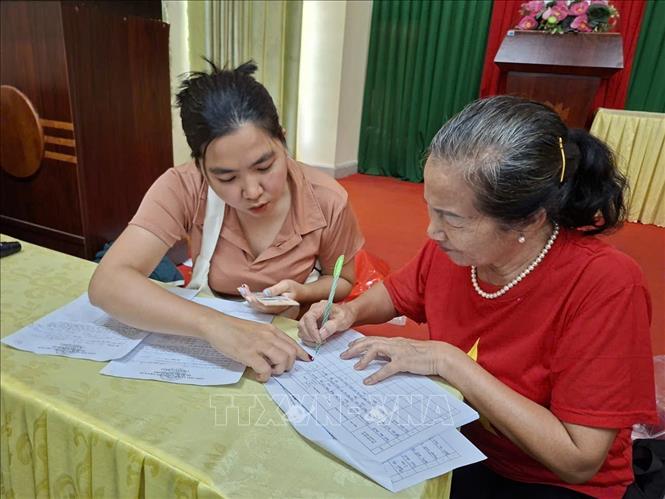 Người dân phường Tam Thắng, TP Hồ Chí Minh ký nhận tiền tại trụ sở khu phố sáng ngày 1/9. Ảnh: Hoàng Nhị - TTXVN