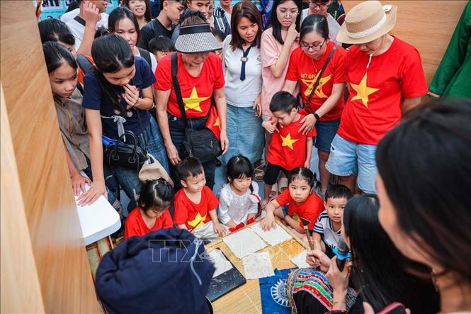 Người dân trải nghiệm vẽ sáp ong tại khu triển lãm Bộ Nông nghiệp và Môi trường. Ảnh: Hoàng Hiếu - TTXVN