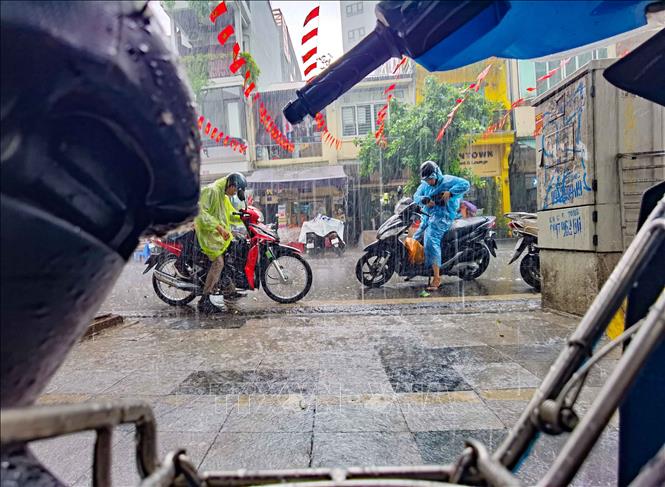 Xuất hiện mưa rào xong nhanh tạnh nên không ảnh hưởng nhiều tới việc đi lại, của người dân, thăm quan phố cổ của du khách. Ảnh: Thanh Tùng - TTXVN