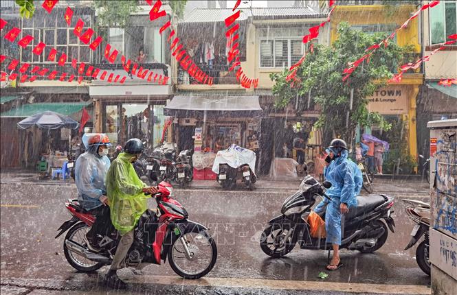 Xuất hiện mưa rào xong nhanh tạnh nên không ảnh hưởng nhiều tới việc đi lại, của người dân, thăm quan phố cổ của du khách. Ảnh: Thanh Tùng - TTXVN