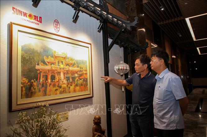 Du khách thích thú ngắm bức tranh vẽ sống động mang sắc màu văn hóa dân tộc trên đỉnh núi. Ảnh: Giang Phương - TTXVN