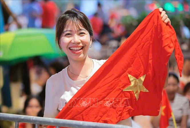 Sắc cờ trên má, nụ cười trên môi. Thế hệ trẻ chúng tôi sinh ra trong hòa bình và niềm tự hào Tổ quốc luôn rực cháy trong tim. Ảnh: Hoàng Hiếu - TTXVN