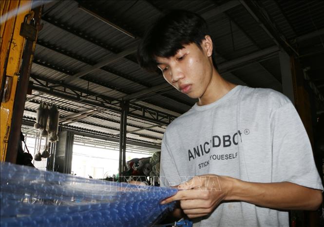 Nhân công làng nghề đang làm lưới giăng mùa nước nỗi. Ảnh: Tuấn Phi-TTXVN