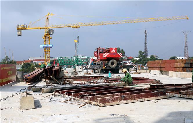 Công nhân lắp dựng hệ thống lan can, hoàn thiện phần trên mặt cầu. Ảnh: Tạ Toàn – TTXVN