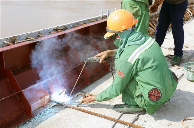 Các đơn vị thi công gấp rút hoàn thiện những hạng mục cuối cùng của cầu Phong Châu mới. Ảnh: Tạ Toàn – TTXVN
