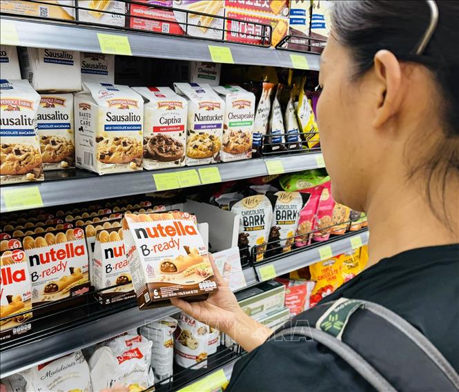 Một người phụ nữ chọn mua thực phẩm tại siêu thị Lotte ở Trung tâm Jakarta. Ảnh: Đỗ Quyên – PV TTXVN tại Indonesia