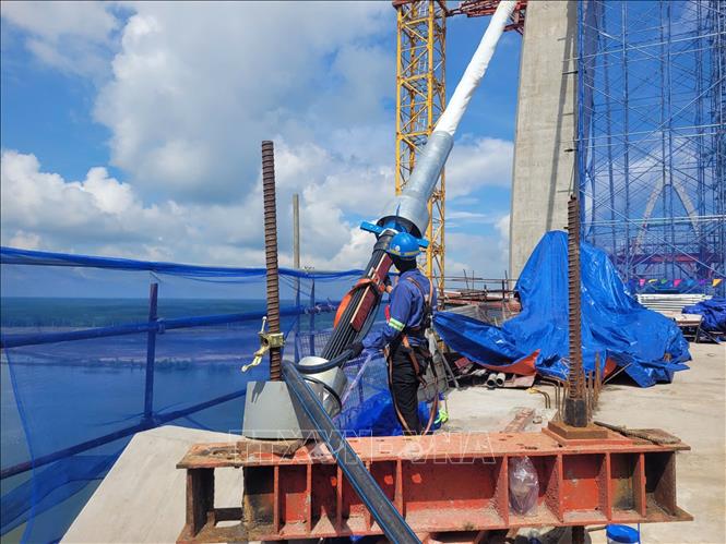 Công nhân thực hiện căng bó cáp dây văng tại dự án cầu Phước An. Ảnh: Hoàng Nhị - TTXVN.