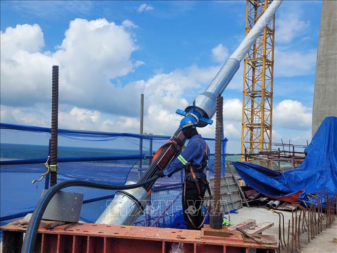 Công nhân căng bó cáp dây văng đầu tiên tại cầu Phước An. Ảnh: Hoàng Nhị - TTXVN.