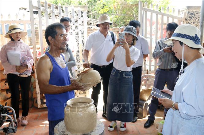 Nghệ nhân trình diễn nghề làm gốm truyền thống của đồng bào Chăm cho du khách tham quan, trải nghiệm. Ảnh: Hồng Hiếu - TTXVN