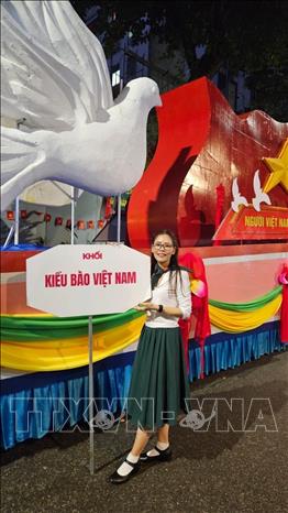 Chị Đào Thị Thu Hằng bên xe diễu hành của khối Kiều bào. Ảnh : TTXVN phát