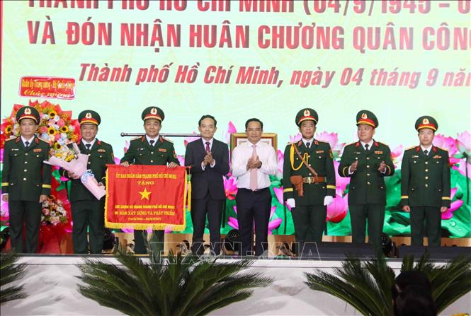 Ông Trần Lưu Quang, Bí thư Trung ương Đảng, Bí thư Thành ủy Thành phố và ông Nguyễn Văn Được, Chủ tịch UBND Thành phố trao tặng Cờ truyền thống của UBND Thành phố cho Lực lượng vũ trang TP Hồ Chí Minh. Ảnh: Xuân Khu-TTXVN