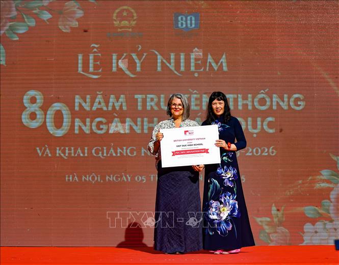 Đại diện đại học Anh quốc Việt Nam (BUV) trao học bổng cho nhà trường. Ảnh: Thanh Tùng - TTXVN