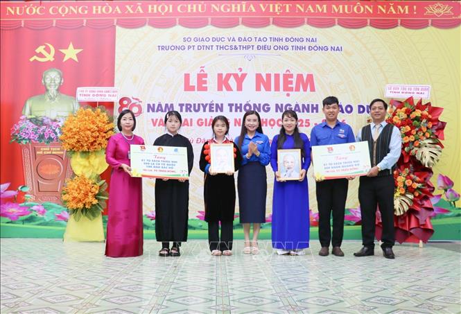 Chị Nguyễn Phạm Duy Trang (giữa), Bí thư Trung ương Đoàn, Chủ tịch Hội đồng Đội Trung ương trao bảng tượng trưng các phần quà tặng Trường Phổ thông Dân tộc nội trú THCS – THPT Điều Ong (xã Bù Đăng, tỉnh Đồng Nai) tại Lễ khai giảng năm học mới. Ảnh: Nhật Bình – TTXVN