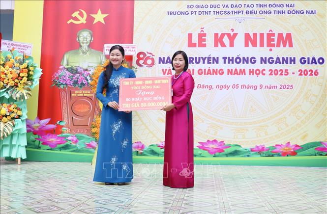 Phó Bí thư Thường trực Tỉnh ủy, Chủ tịch HĐND tỉnh Đồng Nai Tôn Ngọc Hạnh (trái) trao bảng tượng trưng tặng 50 suất học bổng cho học sinh có hoàn cảnh đăc biệt khó khăn của Trường Phổ thông Dân tộc nội trú THCS – THPT Điều Ong (xã Bù Đăng, tỉnh Đồng Nai). Ảnh: Nhật Bình – TTXVN