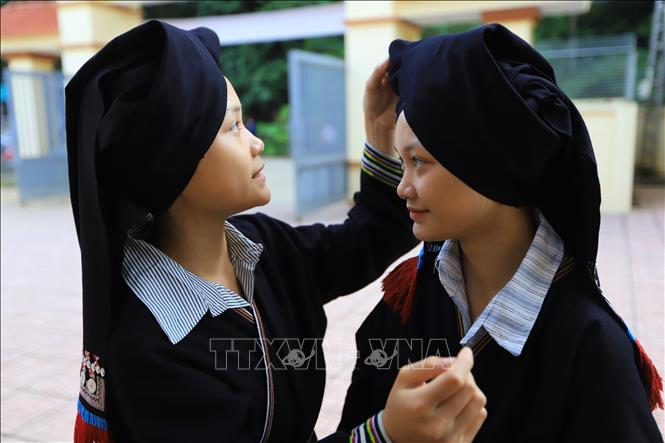 Hai chị em Nhật Anh, Hà Anh người dân tộc Dao xóm Mó Nẻ chuẩn bị trang phục dự khai giảng năm học mới tại Trường PTDTBT TH&THCS Vầy Nưa xã Tiền Phong. Ảnh: Trọng Đạt-TTXVN