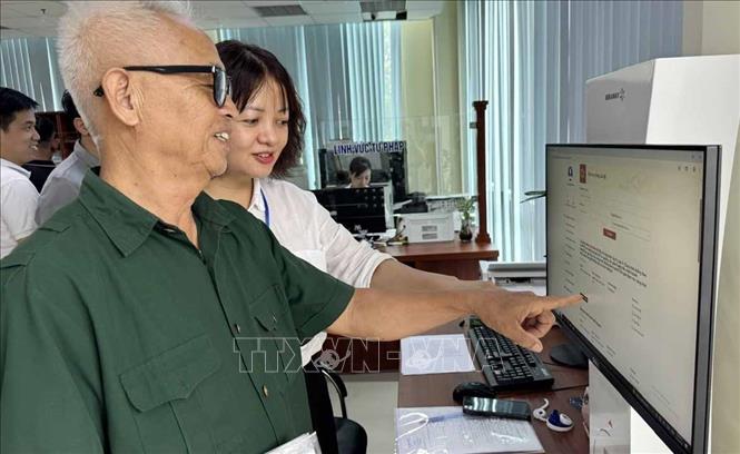 Hướng dẫn người dân phường Hạc Thành (Thanh Hóa) làm thủ tục hành chính tại Trung tâm Phục vụ hành chính công. Ảnh: Việt Hoàng - TTXVN