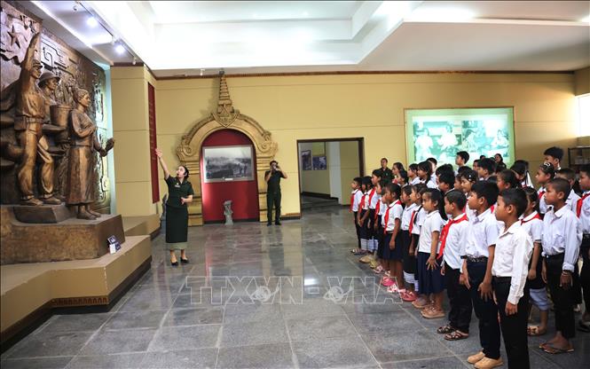 Học sinh trường Dongsavanh, huyện Sepon (Savannakhet, Lào) nghe thuyết minh tại Bảo tàng Liên minh chiến đấu Lào – Việt Nam. Ảnh: Xuân Tú - PV TTXVN tại Lào