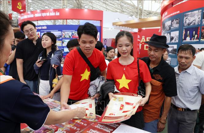 Đổng đảo nhân dân xếp hàng nhận ấn phẩm của Thông tấn xã Việt Nam được trưng bày trong triển lãm. Ảnh: Quốc Khánh - TTXVN