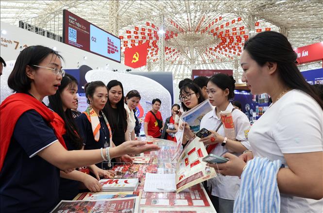 Đổng đảo nhân dân xếp hàng nhận ấn phẩm của Thông tấn xã Việt Nam được trưng bày trong triển lãm. Ảnh: Quốc Khánh - TTXVN