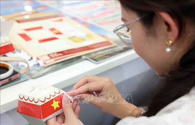 Các ấn phẩm, phụ trang của Thông tấn xã Việt Nam đến tay người dân tại triển lãm. Ảnh: Quốc Khánh - TTXVN