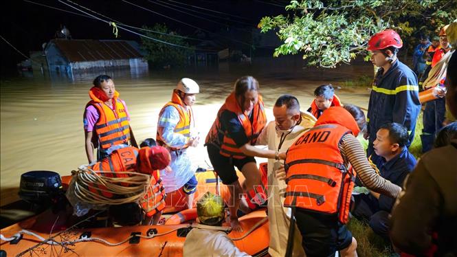 Lực lượng chức năng kịp thời cứu hộ, di dời người dân bị cô lập trong vùng ngập tại xã Hiệp Thạnh đến nơi an toàn ngay trong đêm 5/9. Ảnh: TTXVN phát