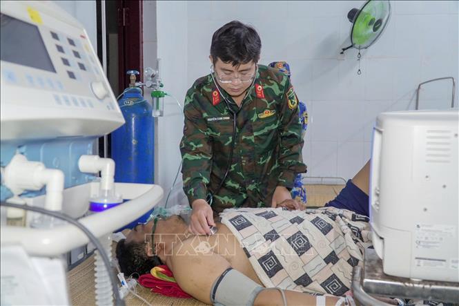 Các bác sĩ Tổ cấp cứu đường không, Bệnh viện Quân y 175 xử trí tại chỗ cho người bệnh ngay tại bệnh xá đảo Song Tử Tây (đặc khu Trường Sa, tỉnh Khánh Hòa). Ảnh: TTXVN phát