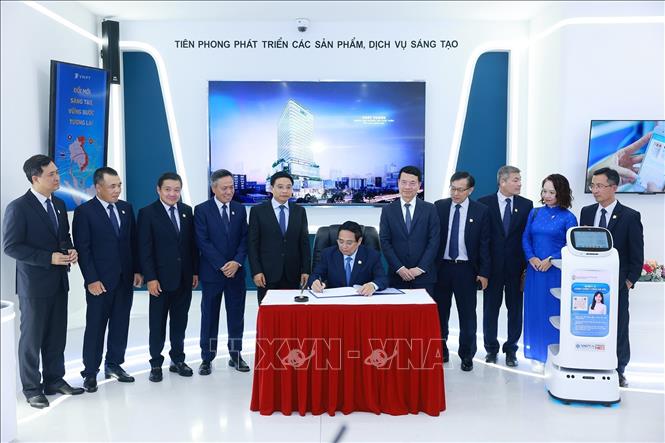 Thủ tướng Phạm Minh Chính viết lưu bút sau khi tham quan Phòng truyền thống và sản phẩm công nghệ của Tập đoàn VNPT. Ảnh: Dương Giang-TTXVN