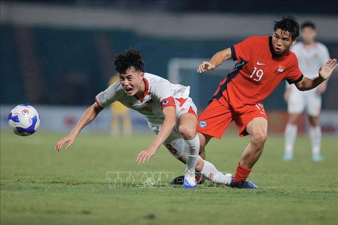 Tình huống phạm lỗi của cầu thủ Jonan Tan (số 19, U23 Singapore) với đội trưởng Văn Trường (số 8, U23 Việt Nam). Ảnh: Minh Quyết - TTXVN