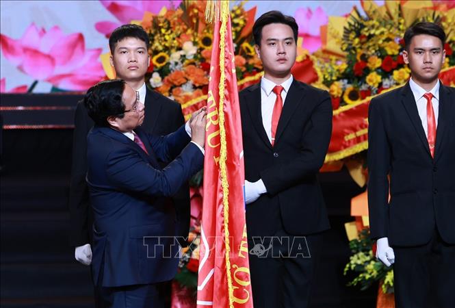 Thủ tướng Phạm Minh Chính gắn Huân chương Hồ Chí Minh lên Cờ truyền thống của Đài Tiếng nói Việt Nam. Ảnh: Dương Giang-TTXVN . Ảnh: Dương Giang-TTXVN
