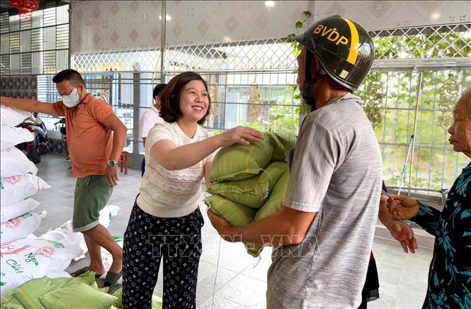  Bà Trần Thị Liễu trao gạo cho người có hoàn cảnh khó khăn trong mùa Vu Lan báo hiếu. Ảnh: Văn Sĩ - TTXVN
