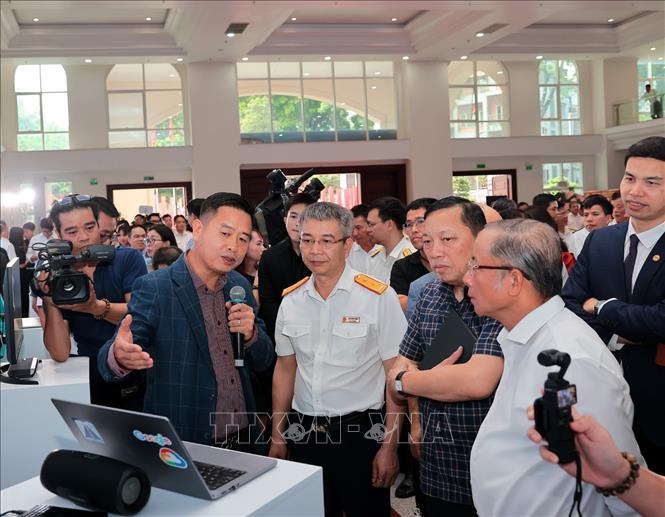 Ông Ngô Hải Phan, Cục trưởng Cục Chuyển đổi số - Cơ yếu Văn phòng Trung ương Đảng và ông Mai Xuân Thành, Cục trưởng Cục Thuế cùng các đại biểu tham quan gian hàng trong Hội chợ. Ảnh: Phạm Hậu – TTXVN