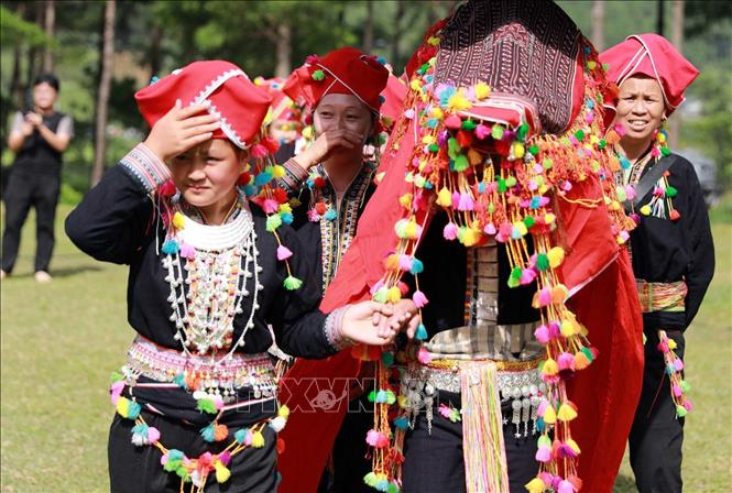 Cô dâu phải trùm kín khăn đỏ trong suốt quãng đường về nhà chồng. Ảnh: Quý Trung – TTXVN