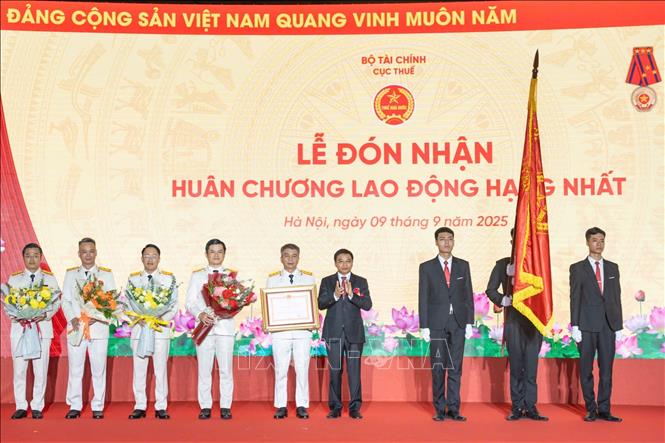 Thừa ủy quyền của Chủ tịch nước, Bộ trưởng Bộ Tài chính Nguyễn Văn Thắng trao Huân chương Lao động hạng Nhất tặng ngành Thuế. Ảnh: Phạm Hậu - TTXVN