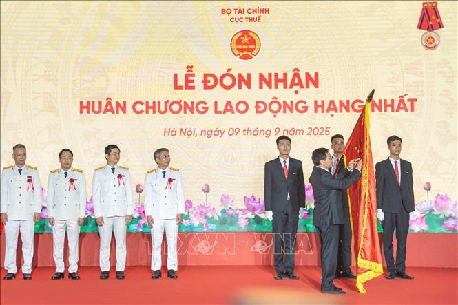 Thừa ủy quyền của Chủ tịch nước, Bộ trưởng Bộ Tài chính Nguyễn Văn Thắng trao Huân chương Lao động hạng Nhất tặng ngành Thuế. Ảnh: Phạm Hậu - TTXVN