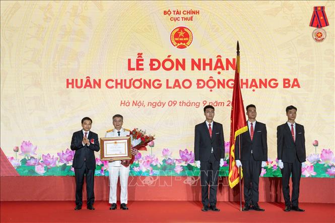 Thừa ủy quyền của Chủ tịch nước, Bộ trưởng Bộ Tài chính Nguyễn Văn Thắng trao Huân chương Lao động hạng Ba tặng Cục trưởng Cục Thuế Mai Xuân Thàn. Ảnh: Phạm Hậu - TTXVN