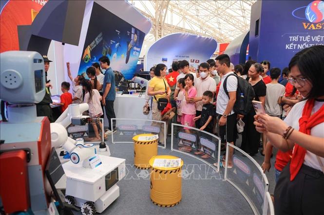 Khách tham quan, tìm hiểu các máy móc tiên tiên tại khu trưng bày Công nghệ thông tin và tự động hóa. Ảnh: Hoàng Hiếu - TTXVN