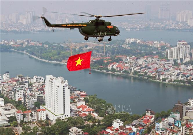Máy bay trực thăng của Quân chủng Phòng không - Không quân treo cờ Tổ quốc bay vào khu vực trung tâm Thủ đô Hà Nội. Ảnh: Trọng Đức - TTXVN