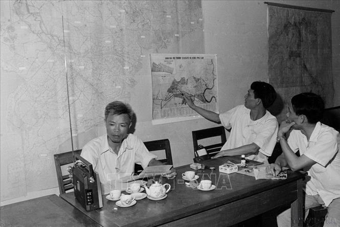 Quá trình hình thành và phát triển của TTXVN luôn đồng hành với sự nghiệp cách mạng, giải phóng dân tộc và dựng xây đất nước. Trong các cuộc kháng chiến thống nhất và bảo vệ Tổ quốc, đội ngũ đông đảo những người làm báo của TTXVN đã thực sự là những nhà báo – chiến sĩ. Trong ảnh: Phó Tổng Giám đốc Thông tấn xã Việt Nam Đỗ Phượng theo dõi tình hình chiến trường trên bản đồ Sài Gòn (1975). Ảnh: TTXVN