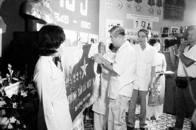 Đồng chí Đàm Quang Trung, Bí thư Trung ương Đảng, Phó Chủ tịch Hội đồng Bộ trưởng trao Huân chương Hồ Chí Minh của Chủ tịch nước tặng TTXVN tại Lễ kỷ niệm 45 năm Ngày thành lập (15/9/1945 - 15/9/1990). Ảnh: Xuân Tuân - TTXVN