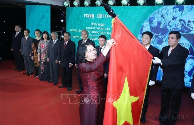 Thừa ủy quyền của Chủ tịch nước, Phó Chủ tịch nước Đặng Thị Ngọc Thịnh gắn danh hiệu Anh hùng Lực lượng vũ trang nhân dân tặng Thông tấn xã Giải phóng lên lá cờ truyền thống của TTXVN tại Lễ kỷ niệm 60 năm Ngày thành lập TTXGP (12/10/1960-12/10/2020). Ảnh: Lâm Khánh-TTXVN