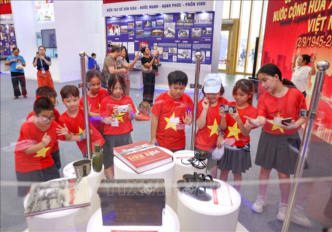 Các em nhỏ thích thú được nhìn ngắm, tìm hiểu về những hiện vật của TTXVN được trưng bày. Ảnh: Thanh Tùng - TTXVN