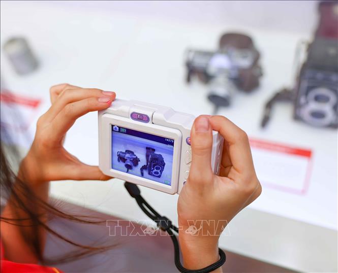 Các em nhỏ thích thú được nhìn ngắm, tìm hiểu về những hiện vật của TTXVN được trưng bày. Ảnh: Thanh Tùng - TTXVN